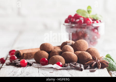 Hausgemachte gesunde vegane Schokolade Trüffel mit Cranberry auf Papier auf weißem Holz Hintergrund Stockfoto