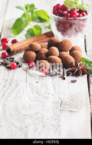 Hausgemachte gesunde vegane Schokolade Trüffel mit Cranberry auf Papier auf weißem Holz Hintergrund Stockfoto