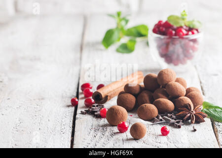 Hausgemachte gesunde vegane Schokolade Trüffel mit Cranberry auf Papier auf weißem Holz Hintergrund Stockfoto