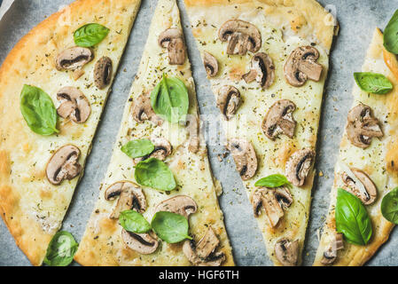 Hausgemachte Pizza mit Basilikum schneiden Sie in Scheiben schneiden, auf Backpapier Stockfoto