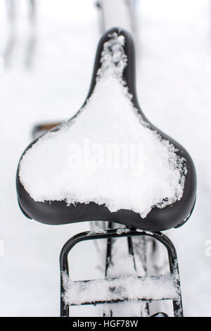 Fahrrad mit Neuschnee bedeckt. Geparkte Fahrrad Detail mit Schnee bedeckt. Das Ende der Bikesaison. Stockfoto