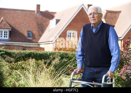 Ältere Mann im Garten unter Verwendung des Rahmens zu Fuß Stockfoto