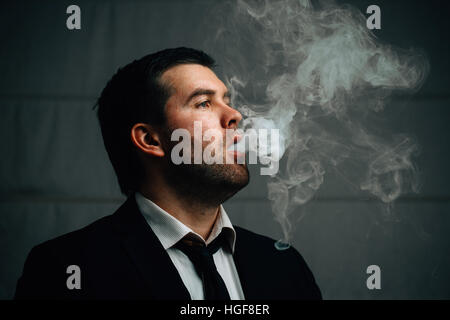 Geschäftsmann ausatmet Zigarettenrauch Stockfoto