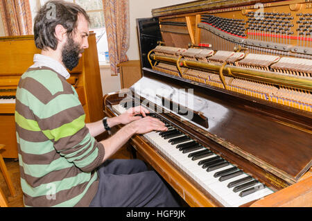 Pianisten Matthew Bourne spielt ein altes Klavier mit gebrochenen Hämmer und Saiten. Stockfoto