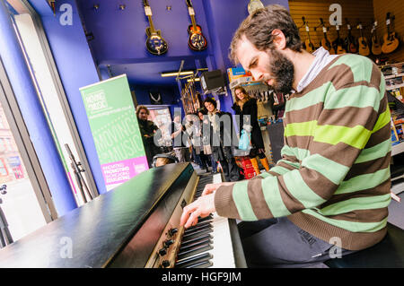 Pianisten Matthew Bourne spielt eine alte Fender Rhodes elektronische Tastatur in einem Musikgeschäft. Stockfoto