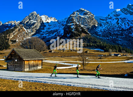 Drei Langläufer Practicising Lauftechnik ohne Stöcke auf improvisierten Langlaufloipen, La Clusaz, Frankreich Stockfoto