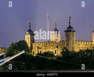 Ein Abend-Schuss der Tower of London, London, England. Kanonen von der HMS Belfast stehen im Vordergrund. Stockfoto