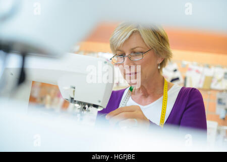 Frau mit Nähmaschine, eingerahmt durch ein weiteres Nähmaschine Stockfoto