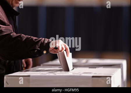 Hand einer Person, die Stimmabgabe bei Wahlen in die Wahlurne Stockfoto