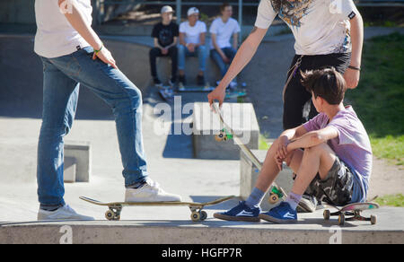 Junge Männer, die Skateboard unter Brücke bei Ralambshovsparken in Stockholm Stockfoto