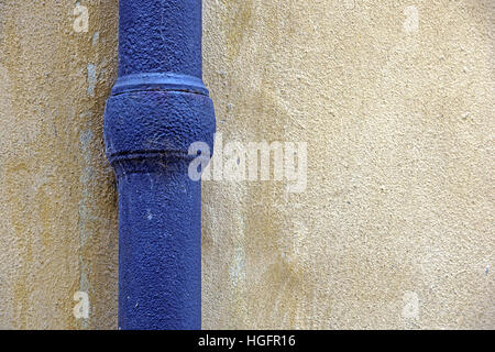 Blaue Regenwasser Rohr hergestellt aus Zinn auf Haus Ecke dekorativen Steinen. Stockfoto