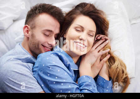 Junges Paar im Bett am Morgen umarmt Stockfoto