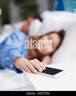 Frau will sich den Wecker ausschalten Stockfoto