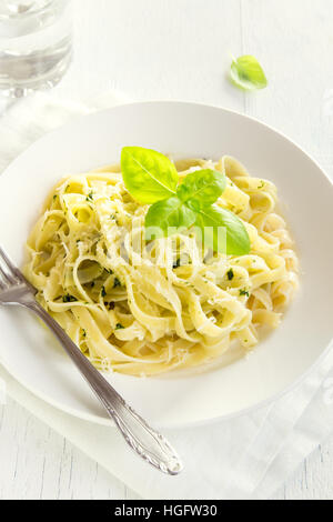 Tagliatelle Nudeln mit Pesto-Sauce, Käse und Basilikum Blätter auf weißen Teller Nahaufnahme - gesunde hausgemachte pasta Stockfoto