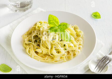Tagliatelle Nudeln mit Pesto-Sauce, Käse und Basilikum Blätter auf weißen Teller Nahaufnahme - gesunde hausgemachte pasta Stockfoto