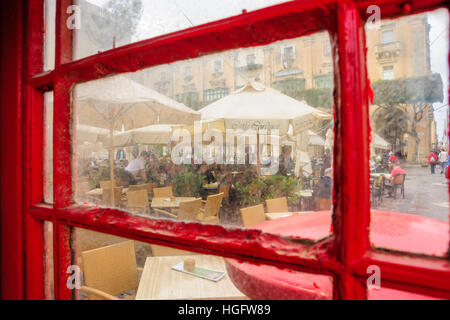 VALLETTA, MALTA - 13. April 2012: Szene aus einem Quadrat mit Restaurants, einheimische und Besucher, aus einer typischen Telefonzelle in Valletta, Malta Stockfoto