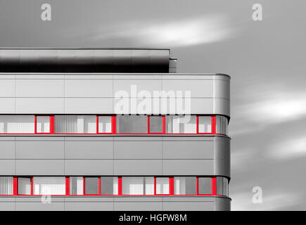 Abstrakt aussehendes schwarze und weißes moderne Gebäude mit roten Fenstern Stockfoto