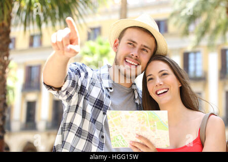 Paar Touristen Beratung eine Anleitung in der Straße von einem touristischen Ort ordnen Sie während der Ferien mit Gebäuden und Palmen im Hintergrund Stockfoto