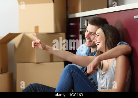 Lässige paar sitzen auf dem Boden der Küche planen Umzug der Möbel des Hauses Stockfoto