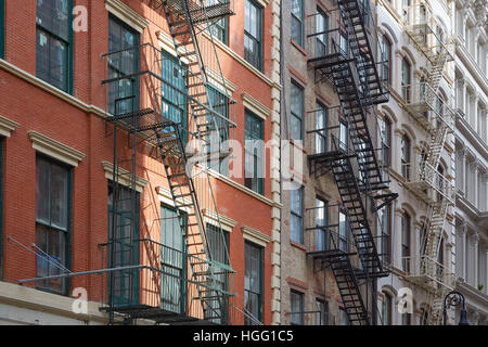 Typische Gebäudefassaden mit Feuerleiter Treppen, Sonne Strahl in Soho, New York Stockfoto