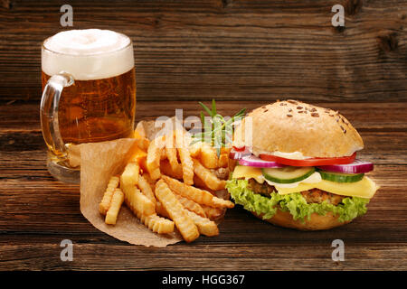 Frische leckere Burger mit Pommes und Bier auf Holztisch mit leeren Platz für text Stockfoto