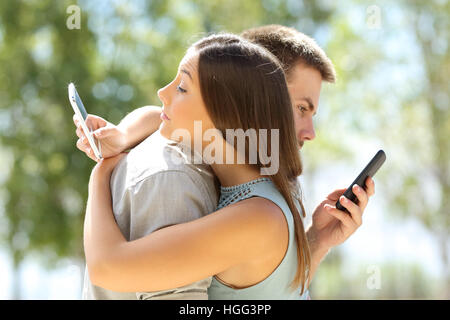 Einige Betrüger umarmt und SMS jeder auf ihre Smartphones Stockfoto