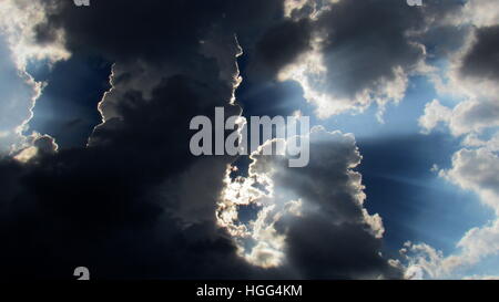 Thunderhead Cloud mit Sonnenstrahlen direkt hinter der großen dunklen Spalte der Wolken Stockfoto
