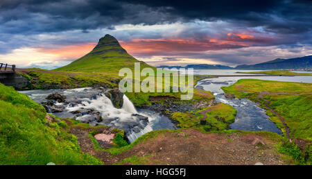 Sommer Sonnenuntergang am berühmten Kirkjufellsfoss Wasserfall und Kirkjufell Berg. Dramatischen Abend Panorama der Halbinsel Snaefellsnes. Stockfoto