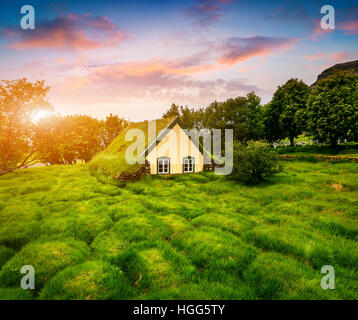 Malerische Rasen-Top-Kirche im kleinen Dorf Hof. Farbenprächtigen Sonnenuntergang in Skaftafell im Vatnajökull-Nationalpark, Südost-Island Stockfoto