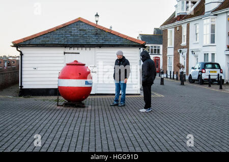 Burnham auf Crouch, Essex. Zwei Männer betrachten alte Naval mine im Riverside Dorf & Holiday Resort am tidal River Crouch. Beliebt bei Seglern & Angler. Stockfoto