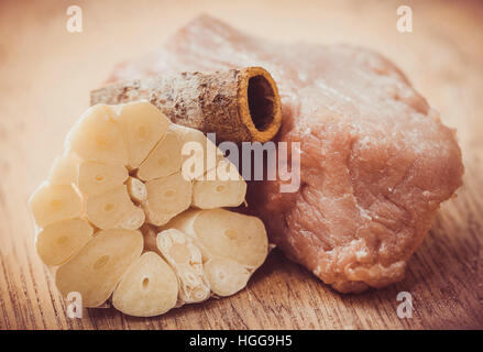 Rohes Rindfleisch mit Knoblauch und Zimt auf Holzuntergrund Stockfoto