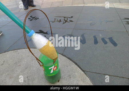 (NUR ZUR REDAKTIONELLEN VERWENDUNG. Qingdao, China CHINA heraus). 9. Januar 2017. Ein Alter Mann schreibt auf dem Boden an einem Platz in Qingdao, Shandong Provinz Ost-China chinesische Kalligraphie Zeichen mit einem riesigen "Pinsel". Viele ältere Menschen wie Pinsel auf dem Boden mit Wasser und einen großen Pinsel in China, die mehr umweltfreundlich schreiben zu üben. © SIPA Asien/ZUMA Draht/Alamy Live-Nachrichten Stockfoto