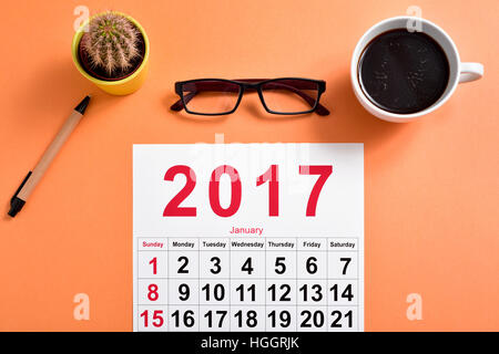 High-Angle Shot von einem Kalender 2017, eine Brille, ein Stift, ein Kaktus und eine Tasse Kaffee auf einem Schreibtisch Stockfoto