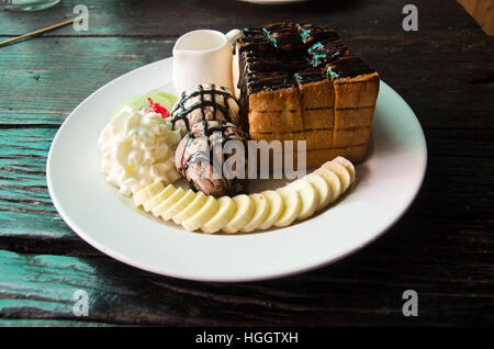 Dekorierte Honig und Schokolade Lava auf Toast mit Banane, Vanilleeis und Schlagsahne im Restaurant thailand Stockfoto