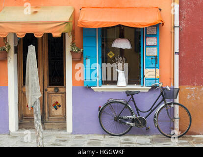 Fahrrad vor einem lila und orange Haus in Burano, Venedig, Italien Stockfoto