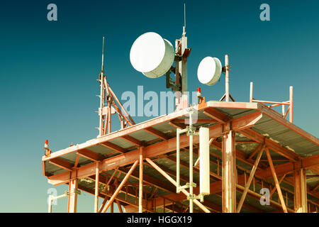 Telekommunikation Turm mit Antennen und klaren blauen Himmel im Hintergrund. Gefilterten Bild: gecrosst wird Vintage-Effekt. Stockfoto