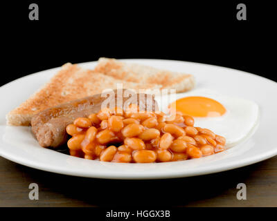 Frisch zubereitete Authentische gebratene Englische Frühstück mit zwei Würstchen Spiegelei und gebackene Bohnen mit Toast als Flach Ohne Menschen Stockfoto
