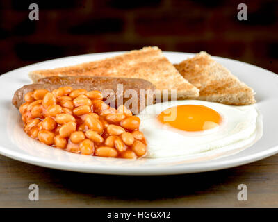 Frisch zubereitete Authentische gebratene Englische Frühstück mit zwei Würstchen Spiegelei und gebackene Bohnen mit Toast als Flach Ohne Menschen Stockfoto