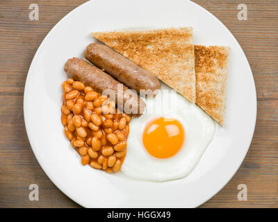 Frisch zubereitete Authentische gebratene Englische Frühstück mit zwei Würstchen Spiegelei und gebackene Bohnen mit Toast als Flach Ohne Menschen Stockfoto