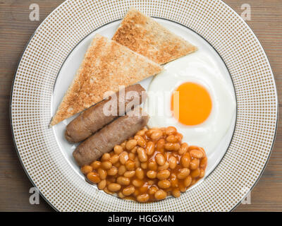 Frisch zubereitete Authentische gebratene Englische Frühstück mit zwei Würstchen Spiegelei und gebackene Bohnen mit Toast als Flach Ohne Menschen Stockfoto