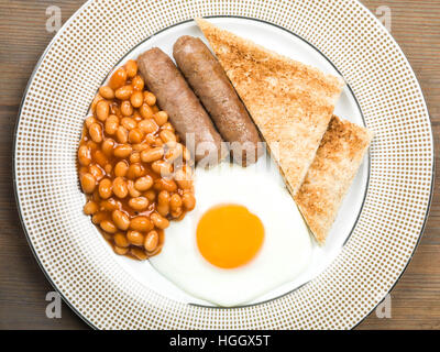 Frisch zubereitete Authentische gebratene Englische Frühstück mit zwei Würstchen Spiegelei und gebackene Bohnen mit Toast als Flach Ohne Menschen Stockfoto