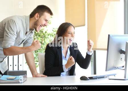 Aufgeregt, Geschäftsleute, Co-working-beobachten einen Desktop-Computer auf Linie Stockfoto