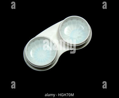 Kontaktlinse Fall gefüllt mit Lösung und Kontakte auf einem schwarzen Hintergrund. Stockfoto