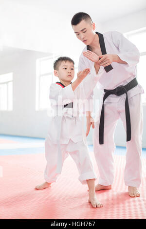 Junge Lehrer unterrichten junge Tae Kwon Do Stockfoto