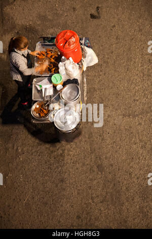 Frau mit Nahrung Wagen an der Sukhumvit Road in der Nacht in Bangkok, Thailand Stockfoto