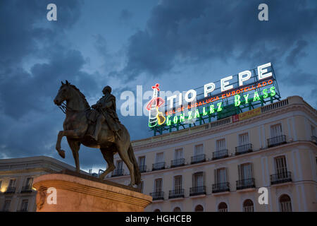 Madrid, Spanien: Equestrian Statue von Charles III von Spanien mit dem Wahrzeichen Tío Pepe anmelden, der Puerta del Sol. Stockfoto