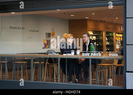 LONDON, UK - 21. JULI 2016.  paar in einem Café in London. Sie sind ein Junge und ein Mädchen, mit einer Tasse Tee oder Kaffee und Blick aus dem Fenster mit Stockfoto