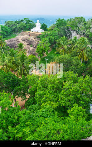 Der Buddha-Statue auf dem felsigen Hügel zu den Gärten von Mihintale Tempel, Sri Lanka. Stockfoto