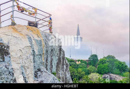 Den steilen Hang des Aradhana-Gala-Rock mit den riesigen Maha Seya Stupa dahinter Mihintale, Sri Lanka. Stockfoto