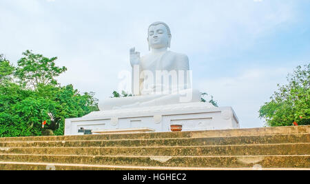 Der Buddha-Statue in Abhaya Mudra Hand darstellen, als Symbol für Sicherheit und keine Angst, befindet sich am oberen Rand Mahindas Hill in Mihintale Tempel, Sri Lanka. Stockfoto